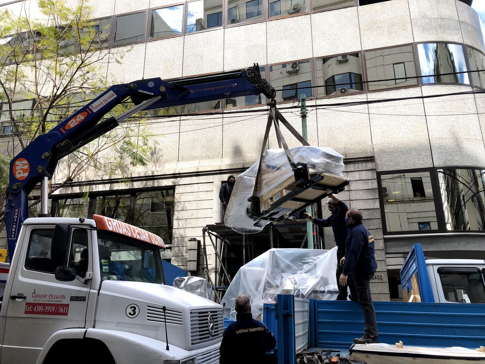 Izaje con grúa de un equipo médico embalado hacia el primer piso de un edificio